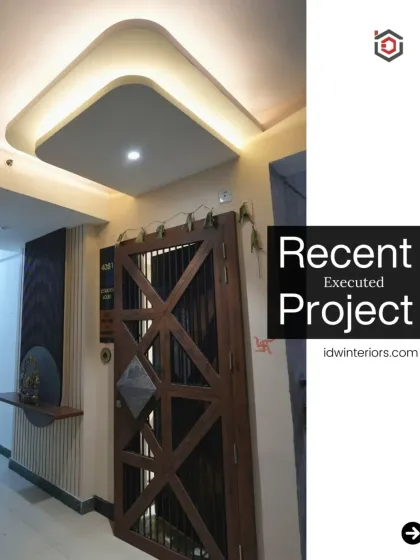 A modern entryway with a geometric-patterned door and a floating shelf for placing keys and small decor. The false ceiling with cove lighting adds a touch of sophistication.
