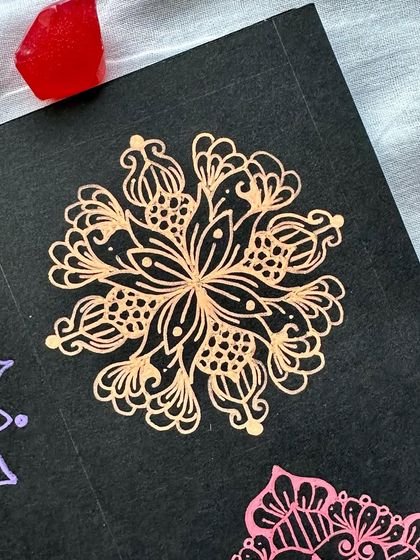 A close-up of a bronze-colored mini mandala from the collection.