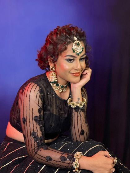 An Indo-Western look created for a professional makeup course. This style features dramatic, colorful eye makeup and a curly updo, paired with modern jewelry.
