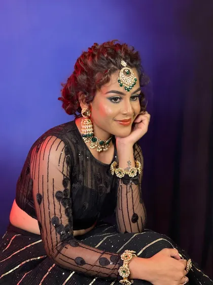 An Indo-Western look created for a professional makeup course. This style features dramatic, colorful eye makeup and a curly updo, paired with modern jewelry.