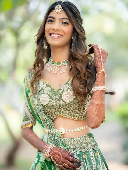The joy on a bride's face is my biggest reward. For this daytime wedding, we went with a fresh, radiant look with soft, wavy hair that perfectly complemented her beautiful green lehenga.