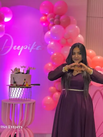 The birthday girl enjoying her pretty-in-pink butterfly-themed party. The shades of pink balloons and custom name sign create a perfect photo backdrop.