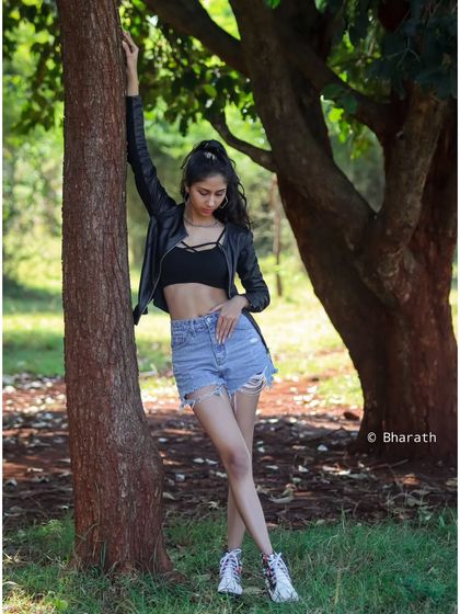 This pose shows off the full outfit in a natural, wooded setting. It's a great example of an outdoor portfolio shot.
