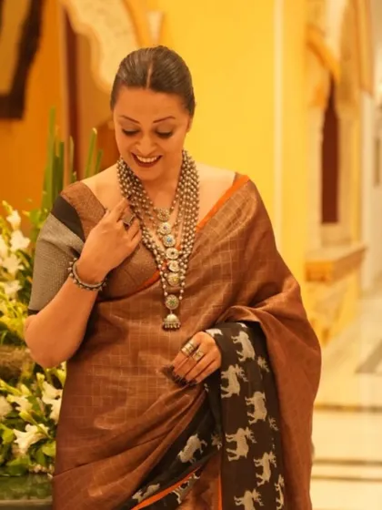 Looking down at the intricate details of the layered necklaces. Accessorizing is key to personalizing a saree look.