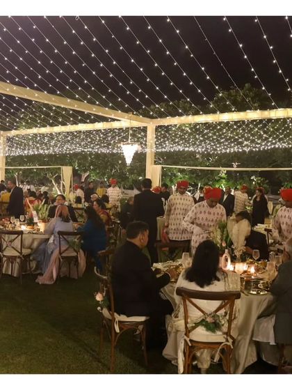 A wide shot capturing the grandeur of a large outdoor wedding reception with numerous tables, all impeccably set and serviced by our team.