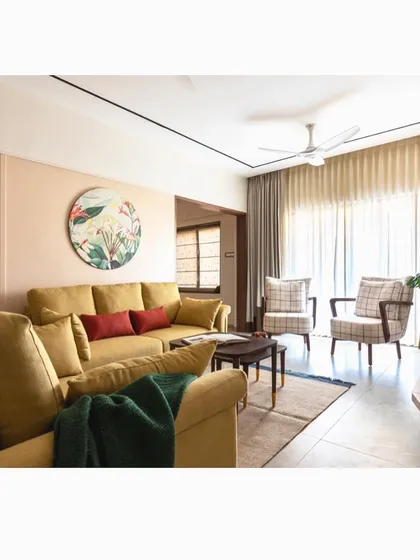 An indie-themed living room featuring a warm, earthy color palette and natural elements. The jute yellow sofa, checked armchairs, and botanical art create a relaxed and stylish atmosphere.