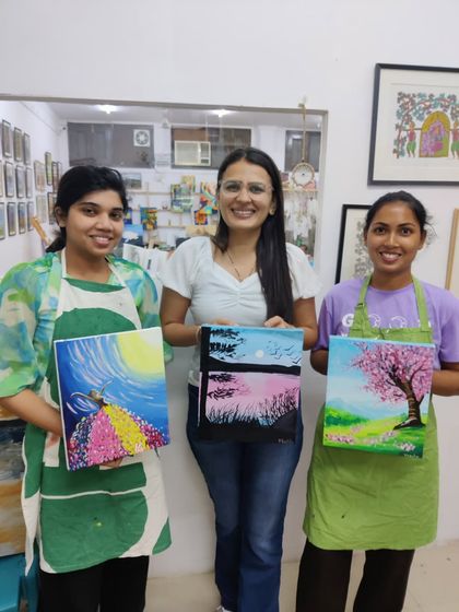 A collection of happy students from our adult canvas painting workshop, each holding their unique and beautiful landscape and abstract creations.