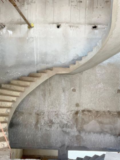 Another angle of the spiral staircase in progress. The sweeping curve of the raw concrete demonstrates the artistry and precision involved in our structural work, turning a functional element into a masterpiece of form.