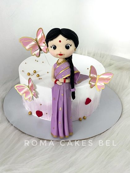 An elegant figurine of a woman in a traditional purple saree, ready to adorn a special celebration cake.
