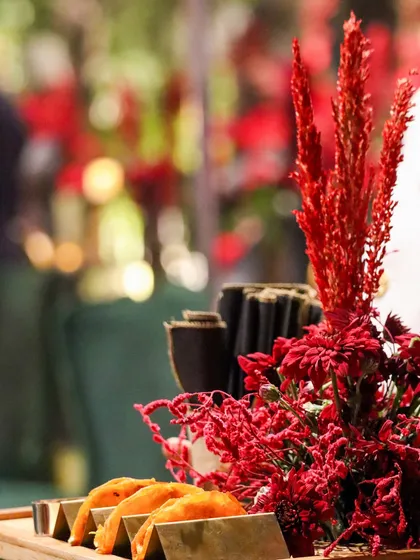 Miniature tacos nestled in custom holders, surrounded by vibrant red floral decor. Every detail of our presentation is thoughtfully considered.