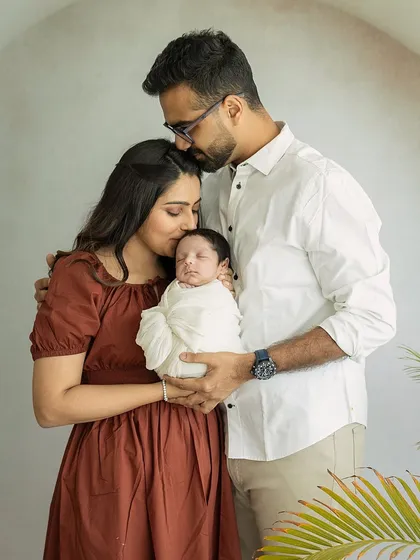 A tender family embrace, with both parents kissing their newborn. This image is a beautiful representation of a family united in love for their new arrival.