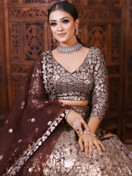 A model posing in a modern bronze and brown lehenga with a unique texture. A great option for a cocktail party or reception.