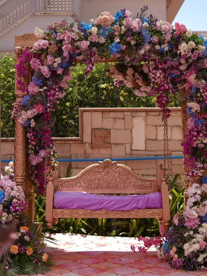 We love creating whimsical corners that become the heart of the celebration. This traditional swing, completely enveloped in a lush arch of pastel florals, became a dreamy photo spot for the couple and their guests at this Mehendi.