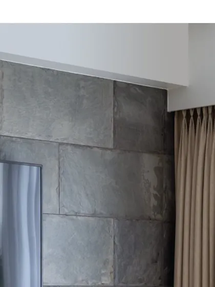A close-up of the corner of the slate tile wall, showing the precision of the installation and the beautiful, rugged texture of the natural stone.