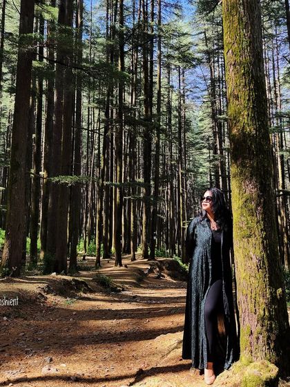 Lost in the serene pine forests of Devalsari. A long, dark shrug provides a layer of warmth and style for a walk in nature.