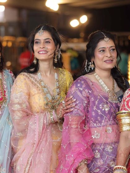 A close-up of our happy clients at a Mayra ceremony. The intricate work on the yellow and purple lehengas, along with the delicate net dupattas, is clearly visible.