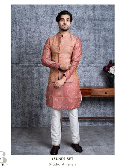 The Versaverve bundi set in a unique peach and pink print. This full-length shot shows how the coordinated pattern on the jacket and kurta creates a distinctive and stylish look.