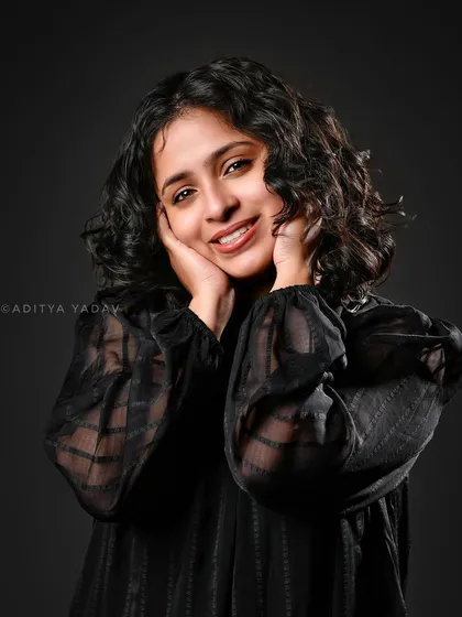 In the studio, it's all about control and precision. For this brand portrait for Annamma Curls, I used a simple dark background and specific lighting to bring out the warmth in her expression and the beautiful texture of her curly hair, creating a clean and engaging image.