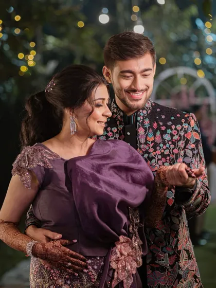 A beautiful couple shot from the sangeet night. The bride's soft and elegant glam complements her partner's look perfectly, creating a picture of love and happiness.