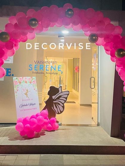 The magical experience starts right at the entrance with a grand pink balloon arch. A themed welcome sign and fairy silhouette cutout greet guests as they arrive at Joshvika's party.