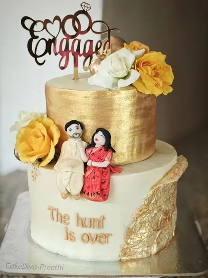 For this two-tier engagement cake, I handcrafted a fondant couple in traditional attire to capture their special moment. The top tier is finished with an edible gold leaf effect, showing how I can personalize a cake to tell your unique love story.