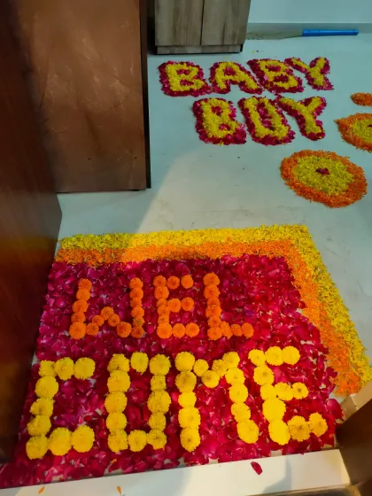 We create beautiful entrances with traditional flower rangoli. This welcome message is handcrafted from fresh marigold and rose petals, making a wonderful first impression for guests arriving at a baby celebration.