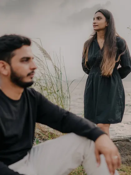 An artistic, moody shot with the groom in the foreground and the bride in the background. This composition creates a sense of longing and introspection, adding depth to their story.