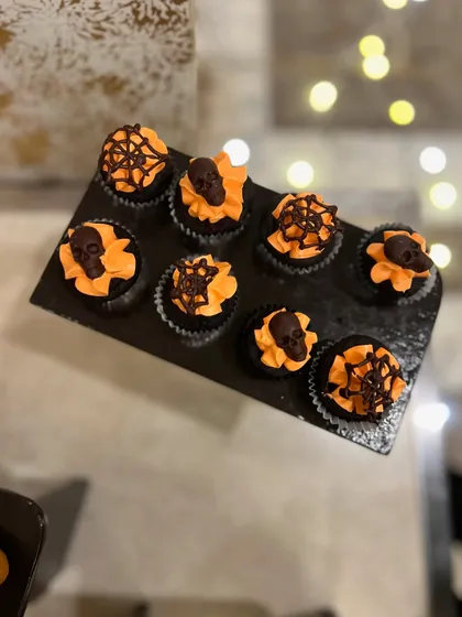 Spooky and delicious Halloween-themed cupcakes. We topped these chocolate cupcakes with orange buttercream and handmade chocolate skulls and spiderwebs.