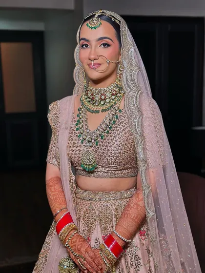 A full portrait of the bride in her gorgeous pastel lehenga. The makeup is soft and dewy, designed to enhance her beautiful features without looking heavy.
