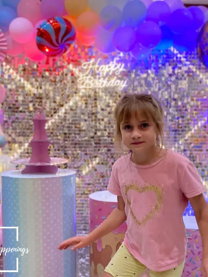 A happy guest enjoying the vibrant atmosphere of the Candyland party. The colorful lights and decorations create a fun and festive mood for everyone.