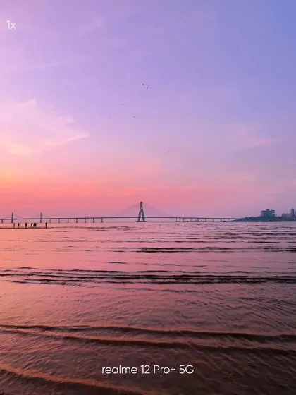 A standard 1x view of the Sea Link from the beach. This mobile photograph serves as a perfect reference point for the various zoom shots, showing the scene as the eye would naturally see it.