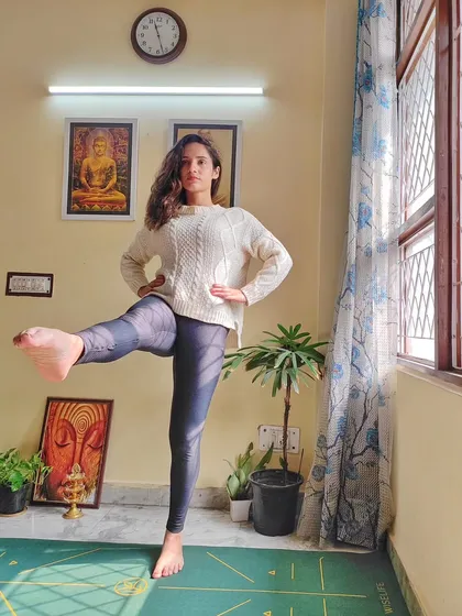 Practicing a standing leg lift. This pose not only challenges your balance but also strengthens your leg muscles and core, teaching you to find stability from within.