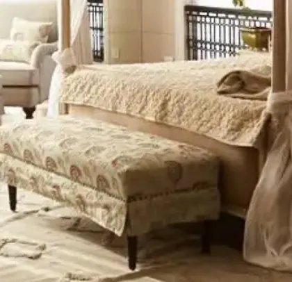 The bedroom seating area in the Goa villa, featuring a custom-upholstered bench at the foot of the bed. The patterned fabric adds a layer of texture and interest, complementing the room's serene and sophisticated aesthetic.