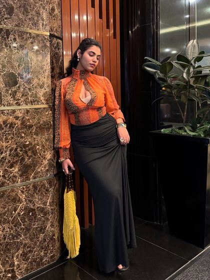 A full-length view of my thrifted outfit. The long black skirt balances the vibrant top, creating an elegant silhouette that's perfect for an evening out.