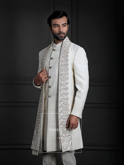 An ivory handloom silk sherwani, adorned with a paisley stole. Here, elegance is not just worn, but felt, cherished, and carried as a legacy across generations.