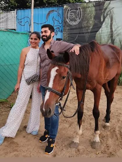 A couple poses with their horse after a ride. The experience doesn't end on the trail; we encourage you to spend time with our gentle horses and create a lasting connection.