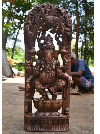 The full view of the 39-inch dancing Ganesha Jali work sculpture, showing the deity on a lotus base, framed by an ornate arch. An artisan can be seen working in the background.