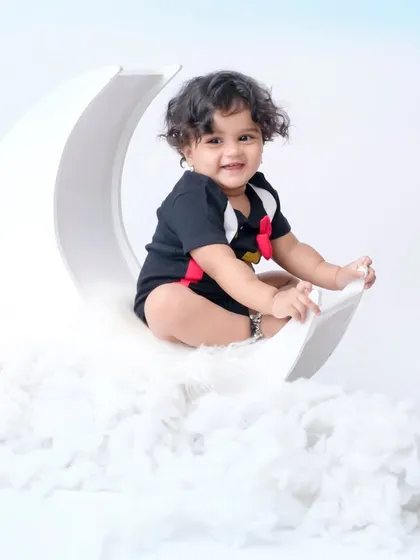 Over the moon! A dreamy portrait of a baby sitting on a crescent moon prop, floating on a bed of clouds. This is one of my most popular and magical setups.