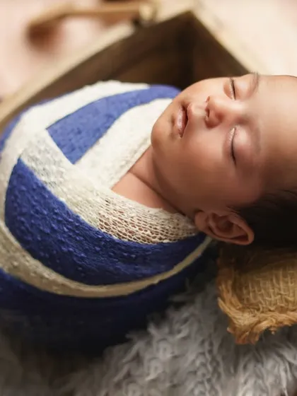 A close-up of the sleeping sailor, resting on a burlap pillow. The textures and colors evoke a feeling of a day at the beach.