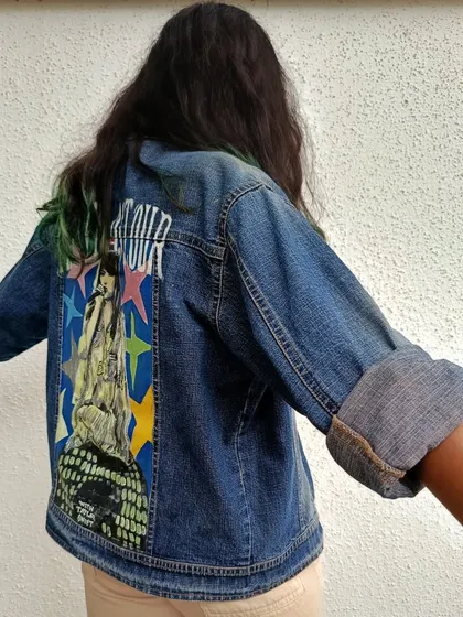 This side view of the Taylor Swift jacket shows how the artwork sits on the denim and how the rolled-up sleeves give it a casual, cool look.
