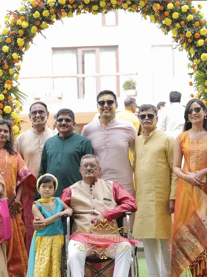 A happy family portrait taken at the Haldi ceremony, with everyone dressed in shades of yellow and orange, perfectly complementing our decor.