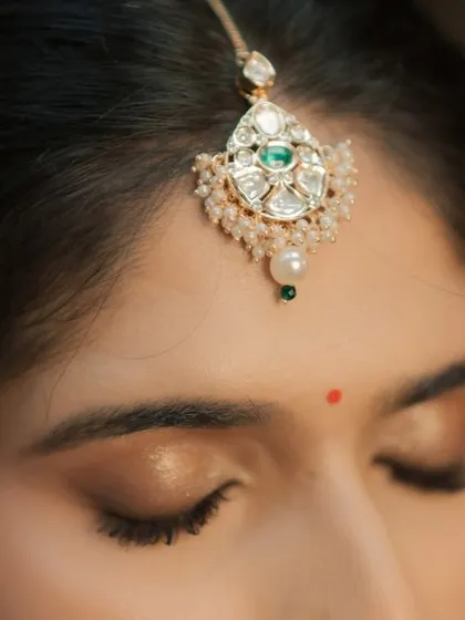 A macro shot of the eye makeup, showing the clean lines and blended colors. The look is finished with a traditional red bindi.