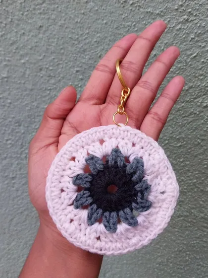 This crochet mandala keychain features a beautiful floral-inspired pattern. It's a unique, bohemian-style accessory for your keys or bag.