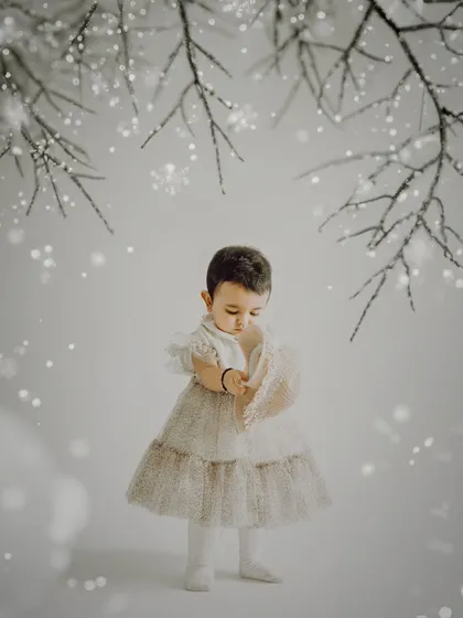A winter wonderland created with AI. We added sparkling snow and frosty branches to this studio portrait, giving it a magical, ethereal feel.