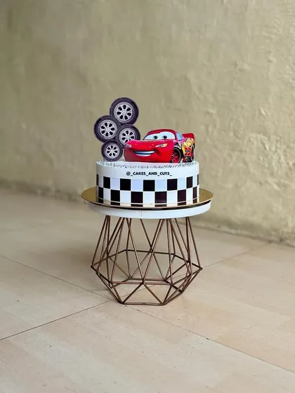 A different take on the Cars theme, this cake features a checkered pattern and a topper with Lightning McQueen and his tire friends.