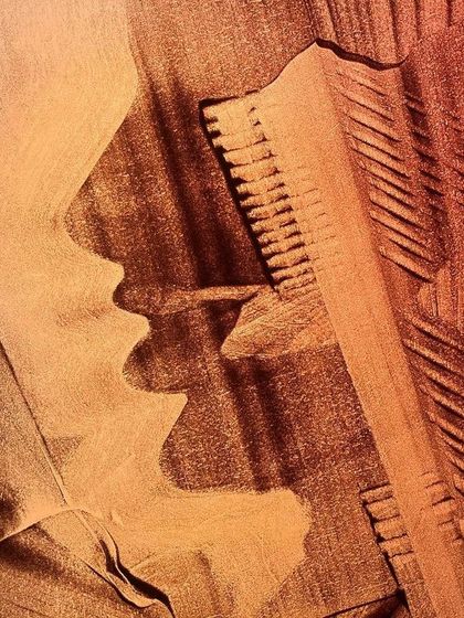 Titled 'Her Choice', this sand painting presents a female profile alongside a comb-like object, exploring themes of identity and decision.