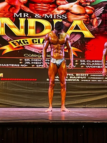 A moment of reflection on stage. This athlete brought incredible conditioning to the Mr. India competition.