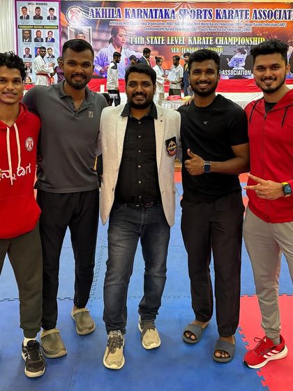The team behind the champion. Posing with fellow coaches and athletes at the state-level karate championship in Hubli.