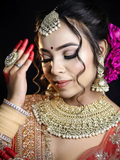 A close-up showcasing the detailed eye makeup and floral hair accessories of a Bengali bride. You will learn to work with fresh flowers and other hair adornments to complete the bridal vision.
