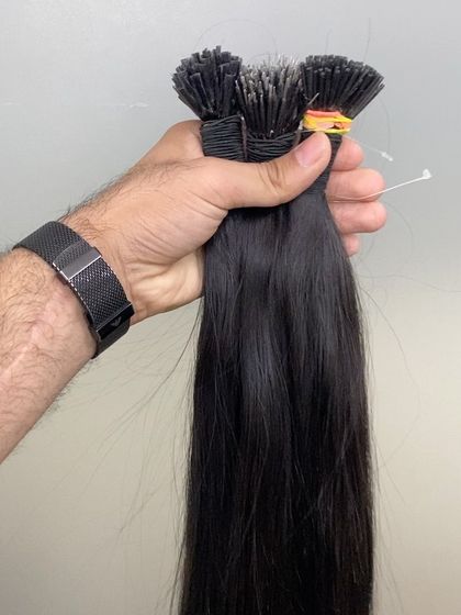 Holding several bundles of our I-Tip extensions, this photo shows the thickness and quality of the hair we provide.